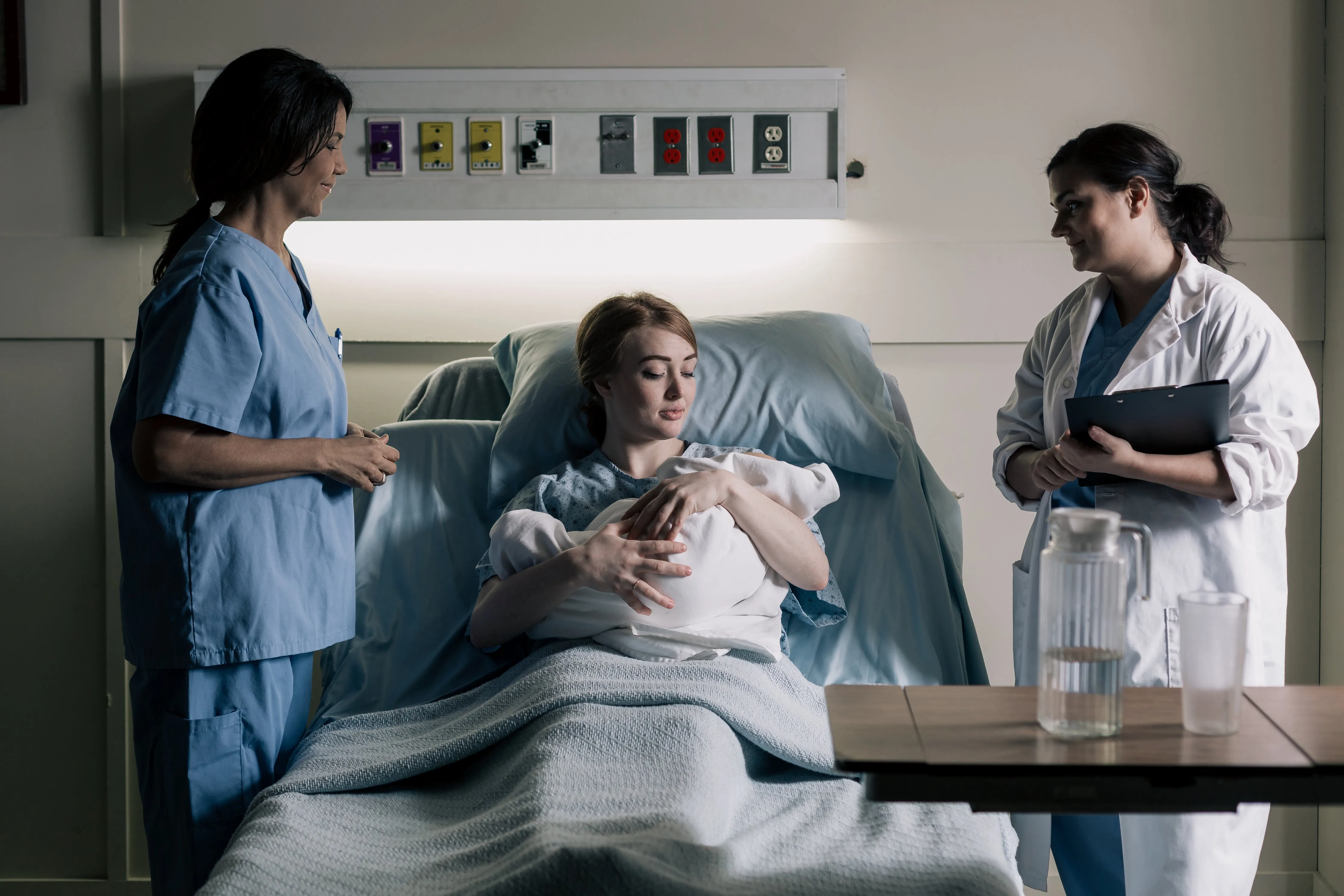 Patient surrounded by doctor and nurse on hospital bed
